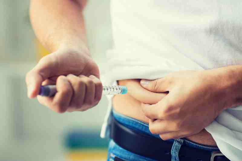 A person injecting insulin into the hip, illustrating the body's impaired insulin production in type 2 diabetes.