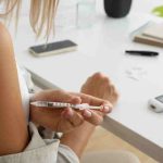Woman checking blood sugar, showing diabetes self-care and family support.