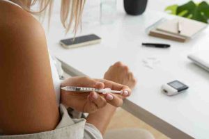 Woman checking blood sugar, showing diabetes self-care and family support.