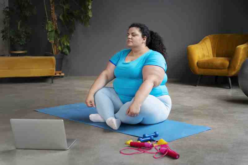 An overweight woman on a yoga mat, representing the link between inactivity, obesity, and type 2 diabetes.
