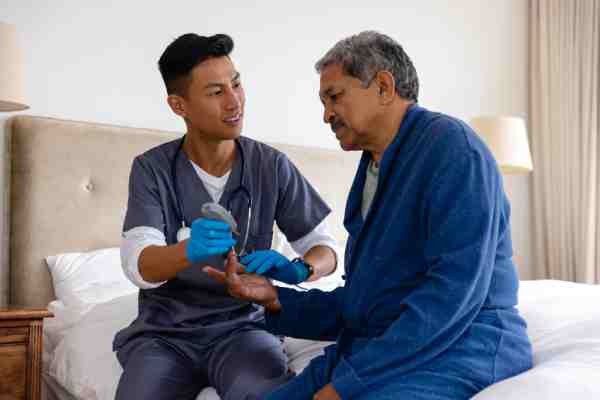 Caregiver assisting a depressed elder with glucose check, highlighting the importance of empathy in mental health care.