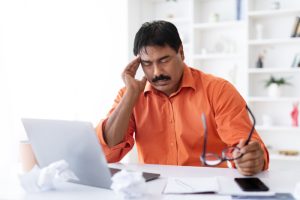A man feeling tired at work, showing a possible symptom of diabetes.
