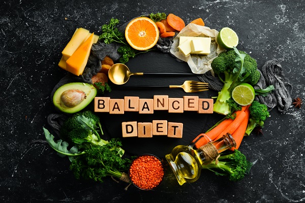 Balanced Diet' written on a block, surrounded by healthy foods, illustrating the impact of malnutrition on diabetes.