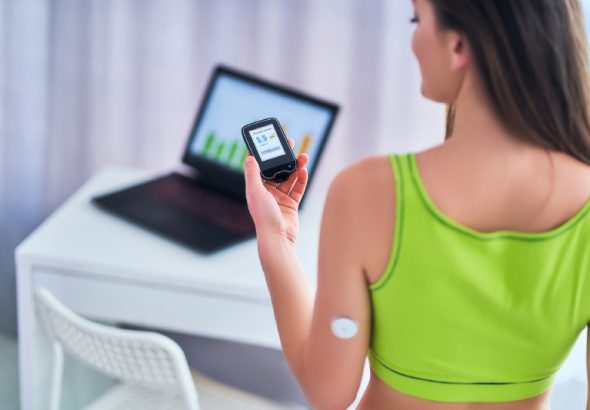 A woman with diabetes using a sensor to check glucose, highlighting the need to monitor blood sugar around exercise.