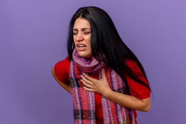 Woman clutches his chest in pain shows symptoms of heart attack.