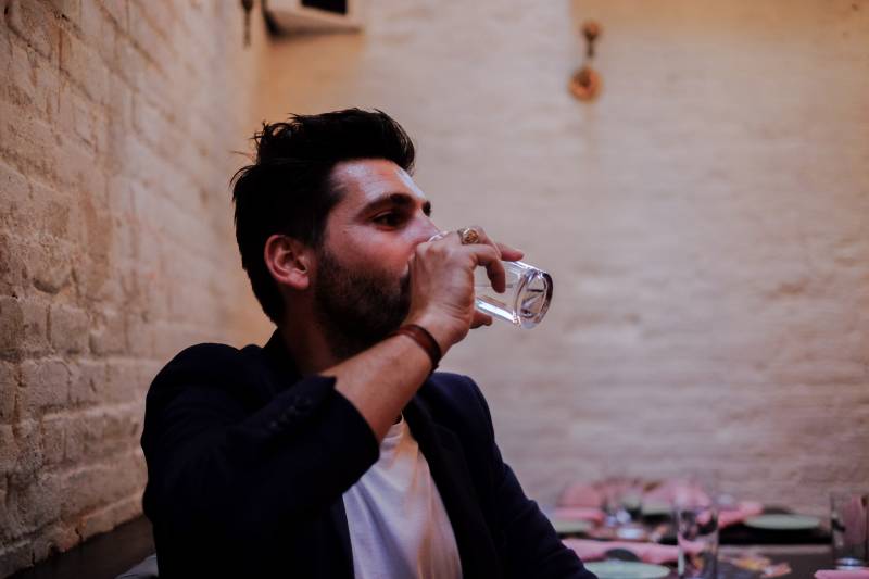 A man experiencing excessive thirst and frequent water intake, a common symptom of type 1 diabetes (polydipsia).