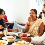 A family at a restaurant confidently ordering Indian food, selecting low glycemic index options to manage diabetes.