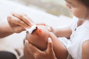 A mother tending to her child’s slow-healing wound, indicating a possible symptom of diabetes.