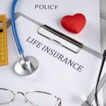 A life insurance policy, stethoscope, and calculator representing insurance options for individuals with diabetes.