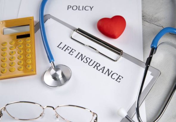 A life insurance policy, stethoscope, and calculator representing insurance options for individuals with diabetes.