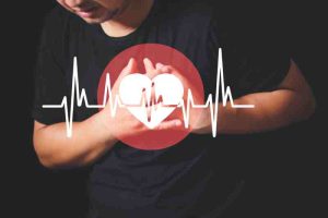 Man clutching his chest with a heartbeat graphic, indicating a symptom of hypoglycemia.