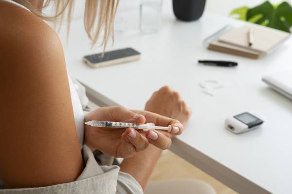 Diabetic woman injecting insulin, emphasizing its role in preventing diabetic ketoacidosis (DKA).