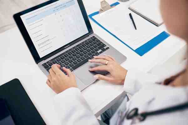 Professional noting a doctor’s appointment, tests, and medications, emphasizing the importance of maintaining health records.