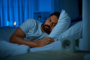 A sleepless man with diabetes lying in bed, showing how lack of sleep can raise blood sugar levels and increase health risks.