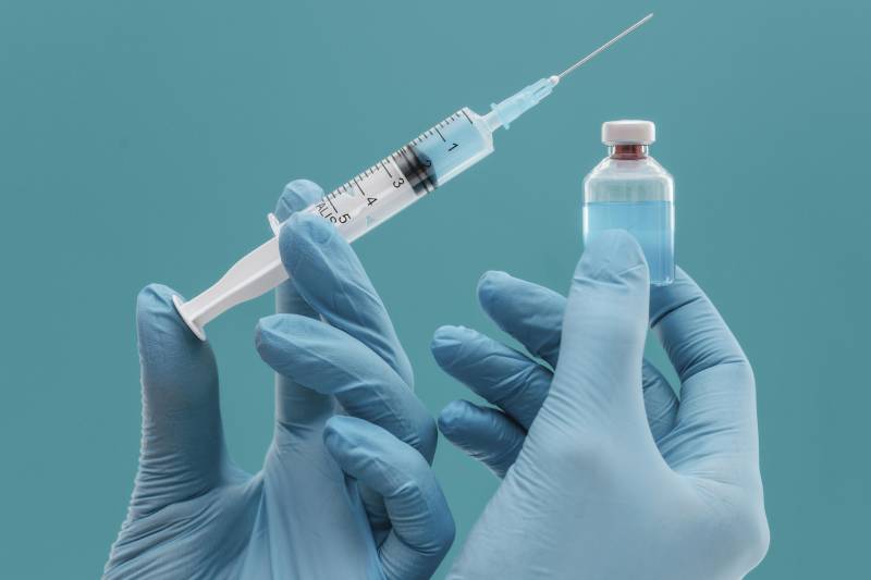 Doctor holding insulin bottle and syringe, representing proper insulin therapy.