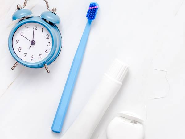 Dental care items and alarm clock representing the importance of oral hygiene, especially for those with diabetes
