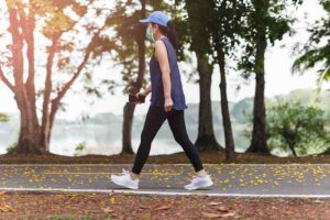 A masked woman taking a quick walk, showing how light activity supports diabetes management.