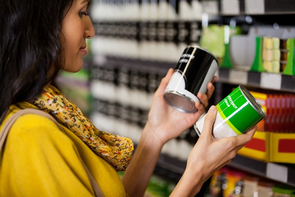 A woman reading nutrition labels on a food packet to manage diabetes.
