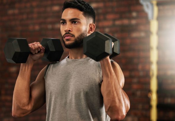 A person with diabetes lifting dumbbells, symbolizing how exercise helps control blood sugar levels.