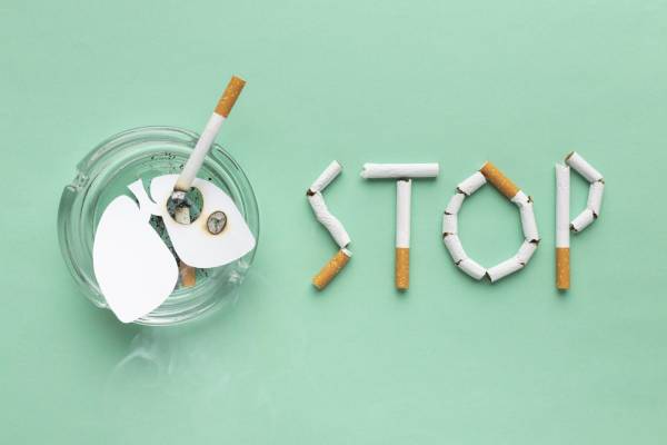 Broken cigarettes spelling “STOP” beside an ashtray highlight smoking’s link to diabetes risk.