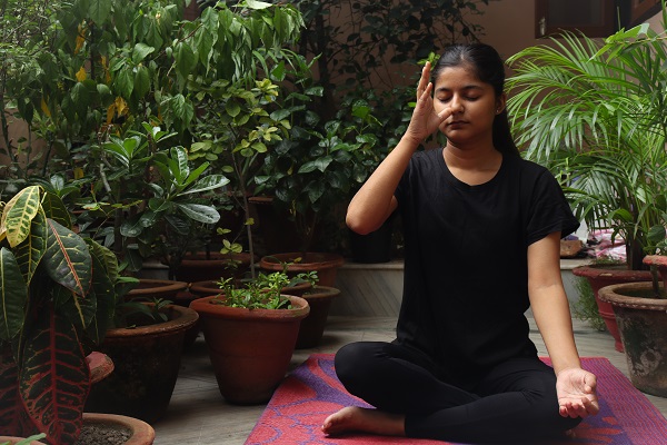 Woman doing yoga with breathing techniques to support heart health and blood pressure