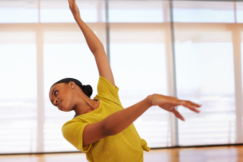 A woman in a dance pose, showing how regular exercise can help regulate blood pressure.