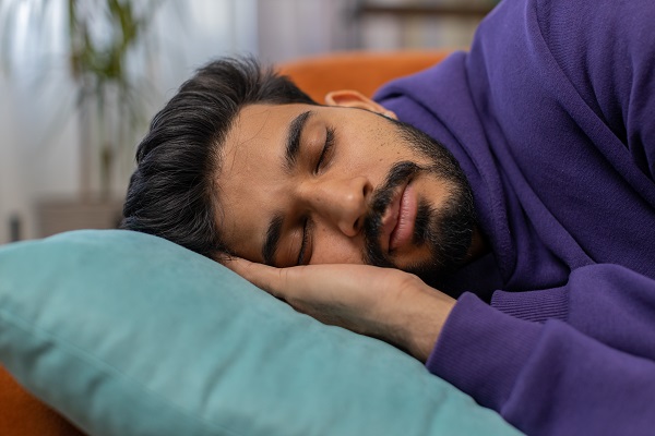 Man is sleeping deeply on a bed, showing that quality sleep boosts the immune system.