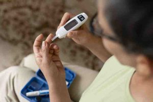 Diabetic woman checking her blood sugar levels, highlighting the risk of silent heart attacks in diabetics.