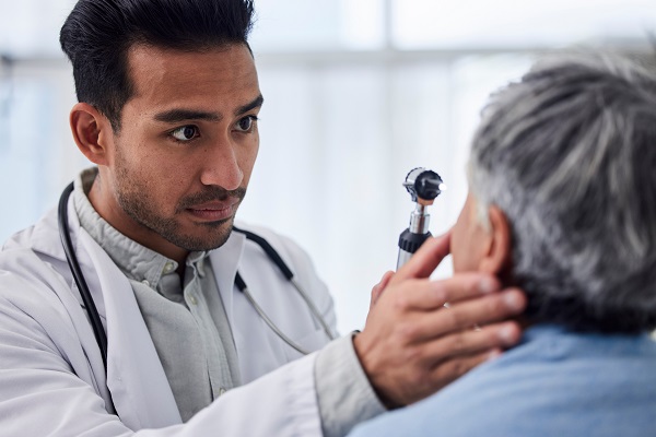 An optometrist checks a patient’s eyes for conditions related to diabetes and high blood pressure.