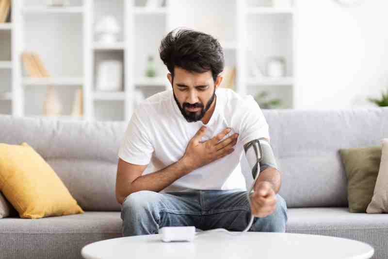 Man holding his chest in pain, representing the warning signs of a heart attack.