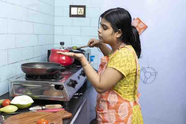 Woman cooking and tasting food, representing how easy it is to follow healthy habits.