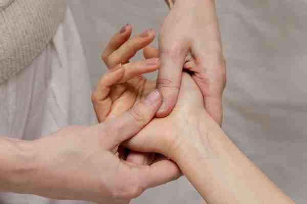 Therapist stimulating the PC6 (Pericardium 6) acupressure point on the patient's wrist.