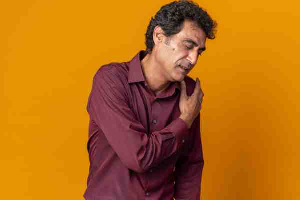Man clutching chest in pain, showing signs of a massive heart attack.