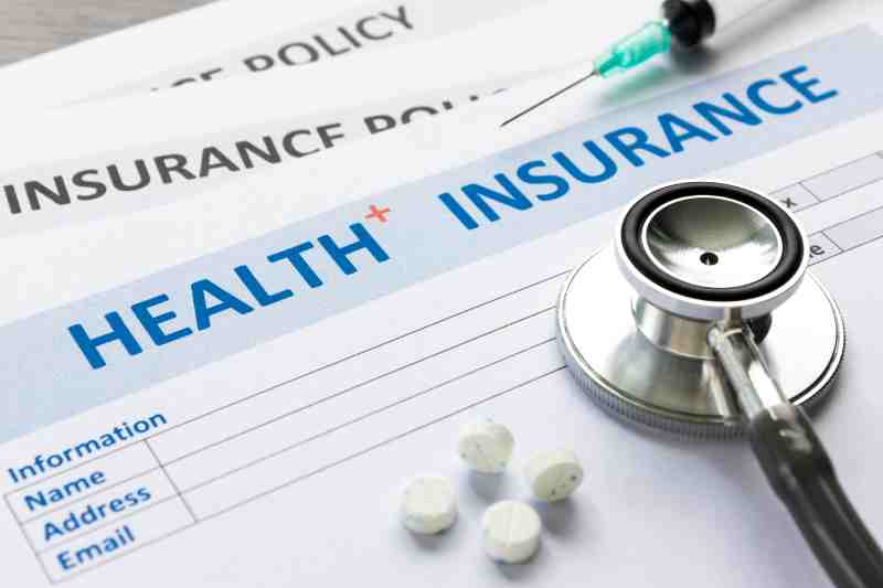 A Health insurance policy, stethoscope, and calculator representing insurance options for individuals with diabetes.