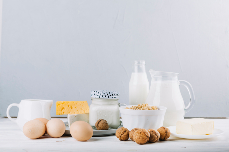 A variety of dairy items and nuts arranged on a table, representing protein-rich foods essential for child growth.