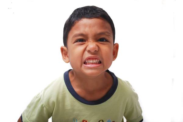 Close-up of an angry boy, reflecting signs of emotional dysregulation.