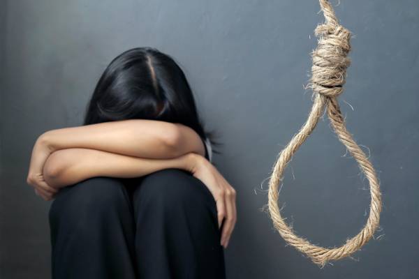 Distressed young girl near a noose, symbolizing severe emotional struggle and the need for support.