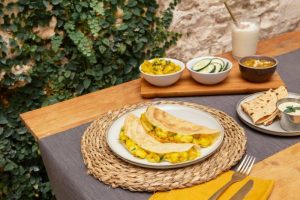 Aloo Gobi, a classic Punjabi dry curry of potato and cauliflower, served with flatbreads and sides.