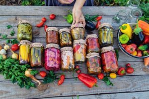 Traditional natural food preservation with pickles in glass jars, reducing food waste and boosting health.