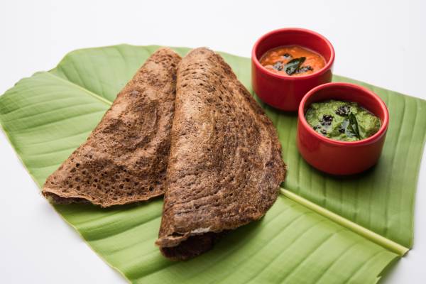 Two dosas with chutneys, reflecting healthier, modern by replacing rice with millet Tamil breakfast.