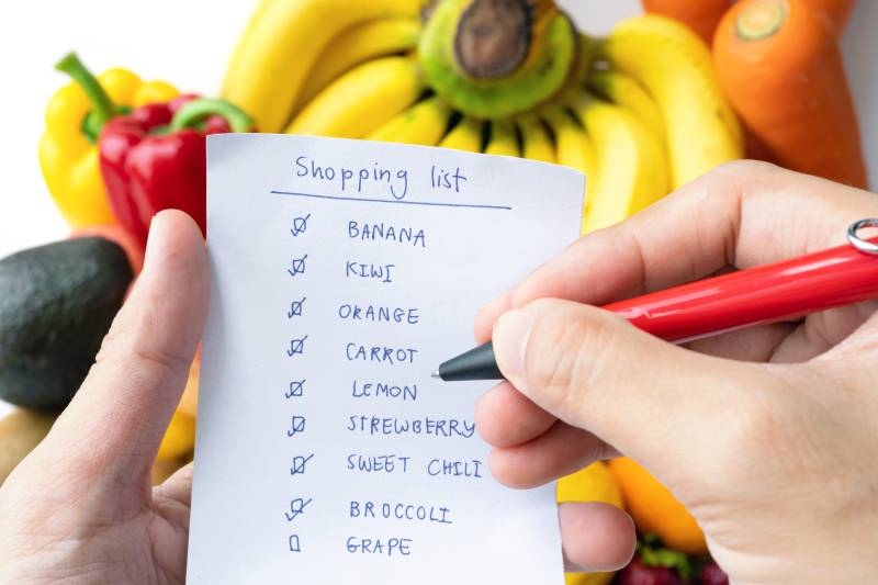 A shopping list with fruits and vegetables, proving healthy eating on a budget is simple.