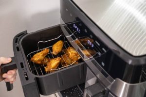 Air fryer with crispy food inside, offering a healthier alternative to deep frying, baking, and steaming.