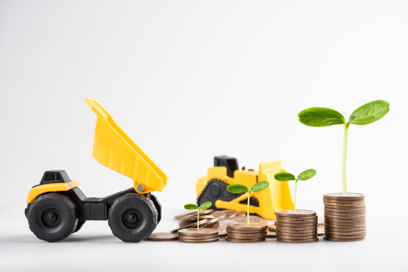 Construction equipment of coins represents business classification based on machinery investment.