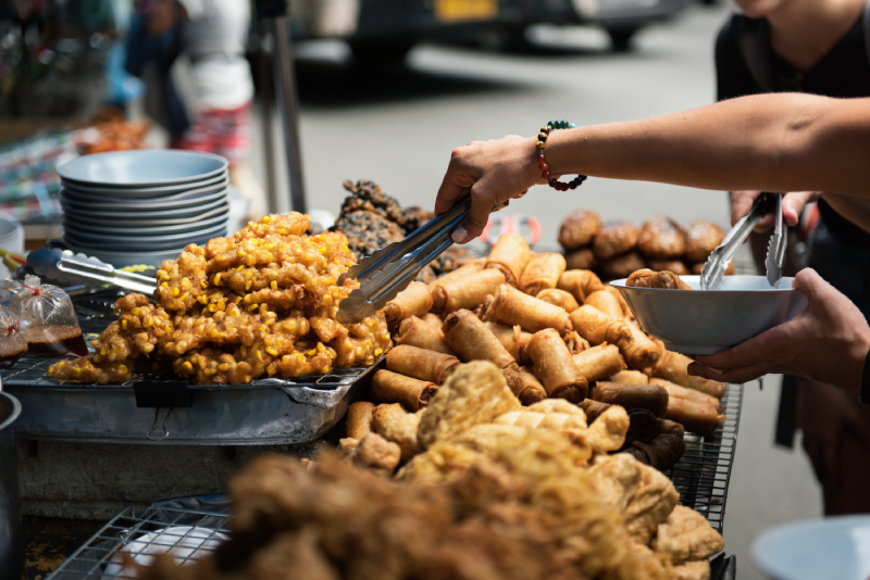 Street food vendor serving fried snacks, stressing that cleanliness of the stall reflects food quality.