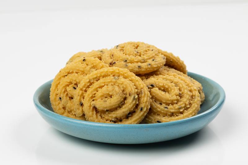 Murukku snacks on a plate, showing festive joy and today’s worry about eating too much rich food.