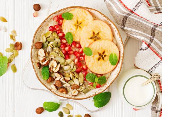 A bowl of yogurt topped with a variety of seeds and nuts, creating a colorful and healthy dish.